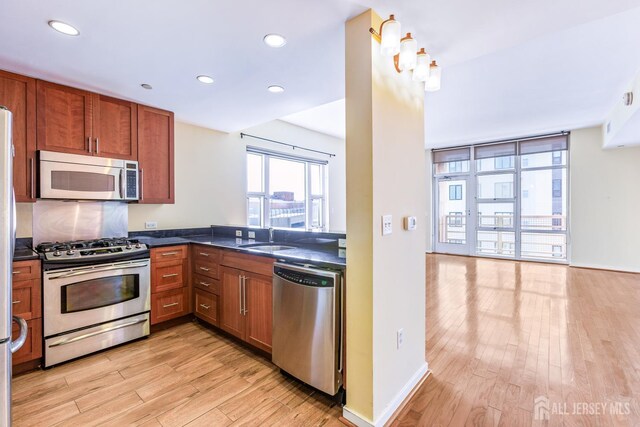 20 Livingston Ave Unit 902, New Brunswick, NJ 08901 - kitchen with stainless steel appliances, light wood finished floors, dark countertops, brown cabinets, and recessed lighting