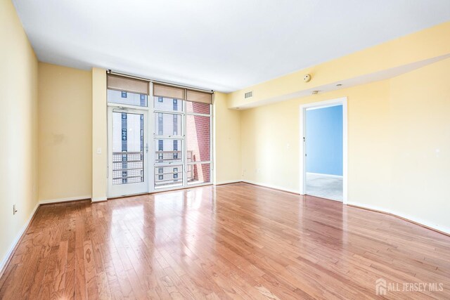 20 Livingston Ave Unit 902, New Brunswick, NJ 08901 - empty room featuring floor to ceiling windows and light wood-style floors