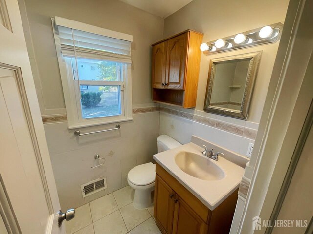 bathroom featuring tile walls, tile patterned floors, vanity, and toilet