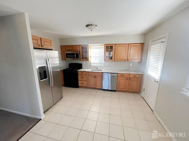 kitchen with sink, stainless steel appliances, and light tile patterned floors