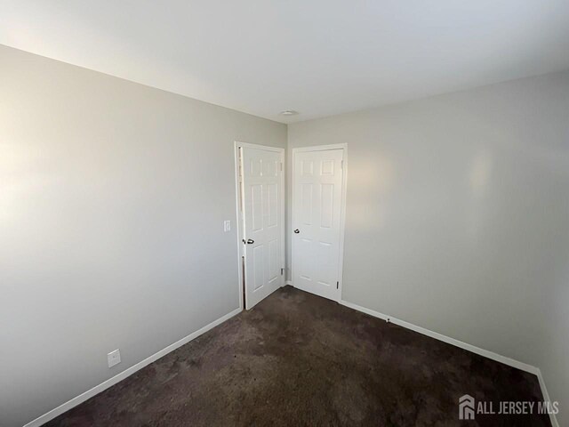 empty room featuring dark carpet