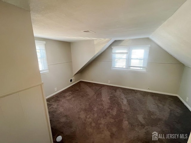 additional living space featuring lofted ceiling and carpet