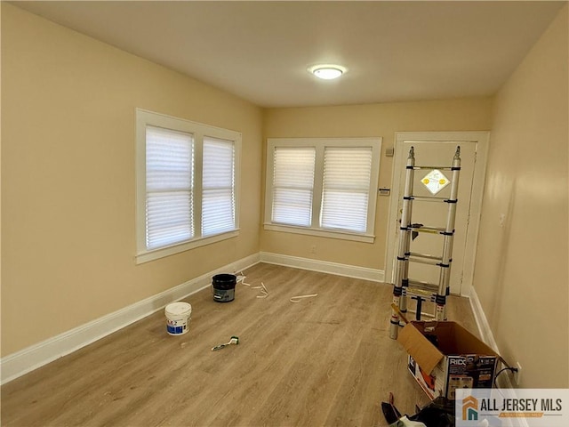 workout area with light wood finished floors and baseboards