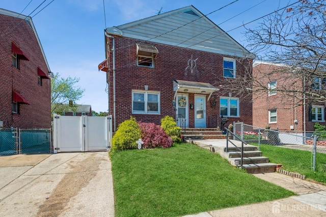 view of front of house featuring brick siding, a gate, fence, and a front yard