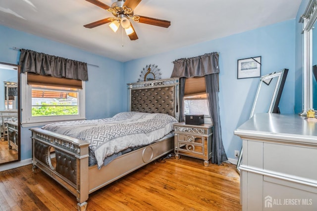 bedroom featuring baseboards, ceiling fan, and wood finished floors