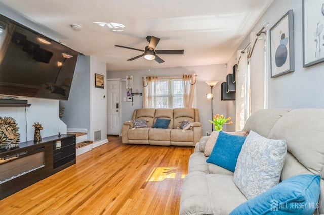 living area with ceiling fan, hardwood / wood-style flooring, and visible vents