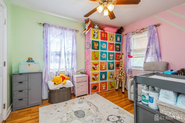 bedroom with multiple windows, light wood-type flooring, and ceiling fan