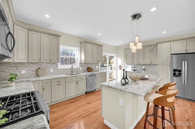 176 Easy St, Edison, NJ 08817 - kitchen with appliances with stainless steel finishes, a sink, a kitchen breakfast bar, a kitchen island, and tasteful backsplash