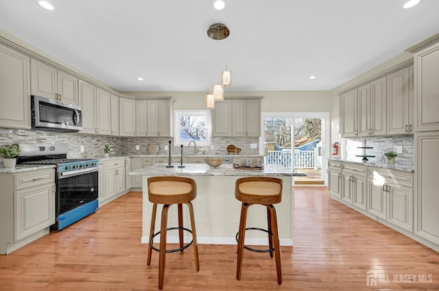 176 Easy St, Edison, NJ 08817 - kitchen with stainless steel appliances, tasteful backsplash, a kitchen bar, light stone countertops, and recessed lighting