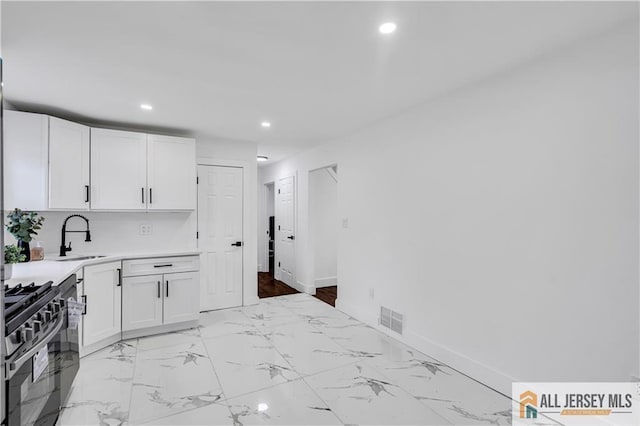 99 Crestview Rd, Fords, NJ 08863 - kitchen with range with gas stovetop, a sink, recessed lighting, light countertops, and white cabinetry
