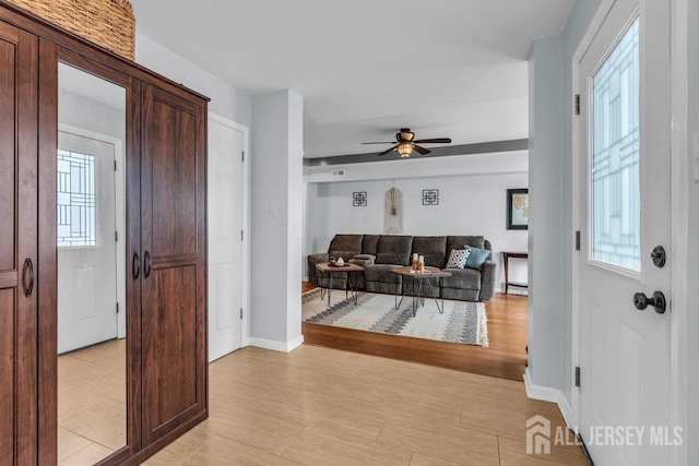 904 4th St, Union Beach, NJ 07735 - foyer with a ceiling fan, baseboards, a healthy amount of sunlight, and light wood-style flooring