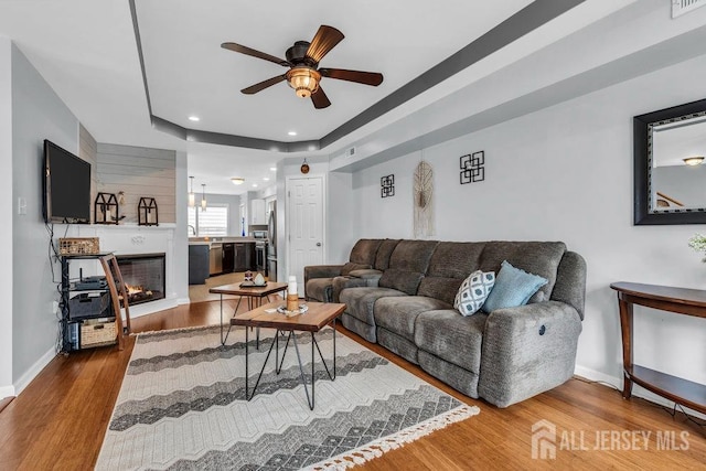 904 4th St, Union Beach, NJ 07735 - living room featuring a ceiling fan, recessed lighting, baseboards, a glass covered fireplace, and wood finished floors