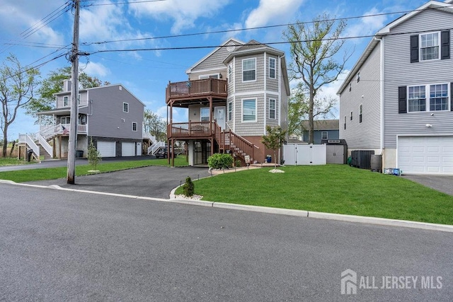 904 4th St, Union Beach, NJ 07735 - view of front facade with stairway, aphalt driveway, fence, and a front yard