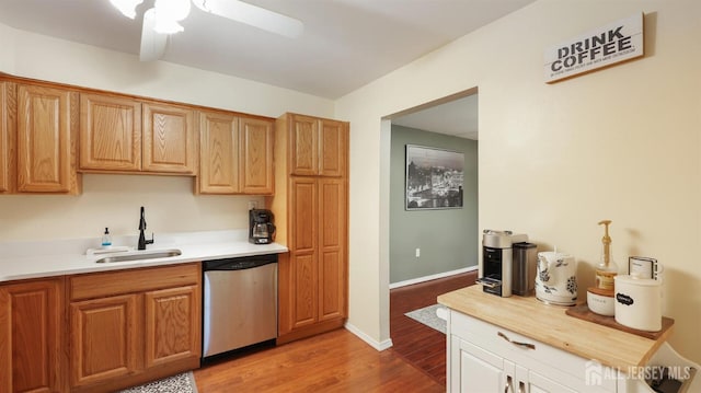 kitchen with ceiling fan, sink, stainless steel dishwasher, and light hardwood / wood-style floors