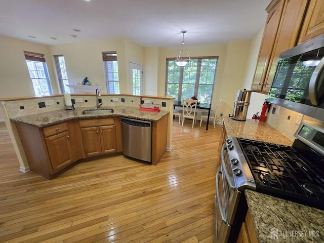 3 Great Beds Way S, Amboy, NJ 08879 - kitchen featuring stainless steel appliances, a sink, light wood-style flooring, brown cabinets, and light stone counters