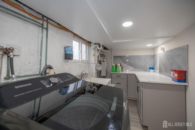 118 Holly St, Port Reading, NJ 07064 - washroom with cabinet space, water heater, and light wood-style flooring