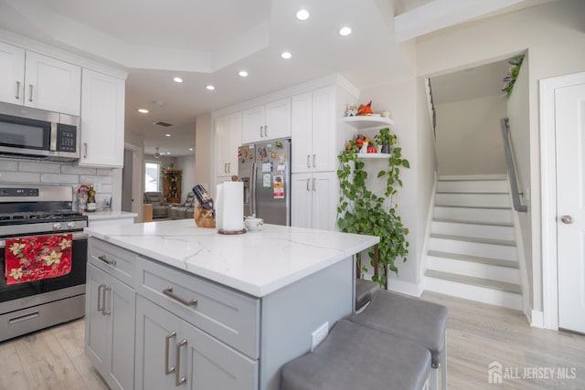 118 Holly St, Port Reading, NJ 07064 - kitchen with appliances with stainless steel finishes, recessed lighting, open shelves, white cabinets, and light wood-type flooring