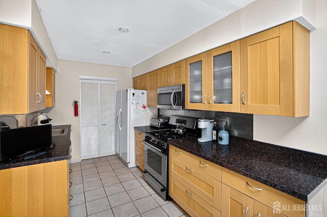 29 Whittney Ct, East Brunswick, NJ 08816 - kitchen featuring appliances with stainless steel finishes, light tile patterned floors, glass insert cabinets, and dark stone countertops