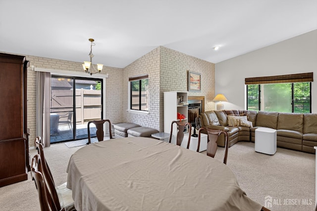 29 Whittney Ct, East Brunswick, NJ 08816 - dining room with carpet, vaulted ceiling, brick wall, a chandelier, and a fireplace