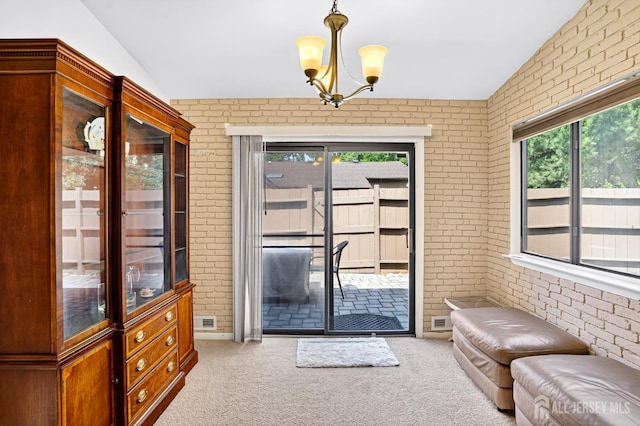 29 Whittney Ct, East Brunswick, NJ 08816 - entryway featuring brick wall, healthy amount of natural light, carpet, a chandelier, and vaulted ceiling