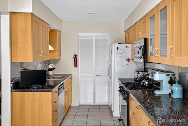 29 Whittney Ct, East Brunswick, NJ 08816 - kitchen with appliances with stainless steel finishes, light tile patterned floors, glass insert cabinets, dark stone counters, and light brown cabinetry