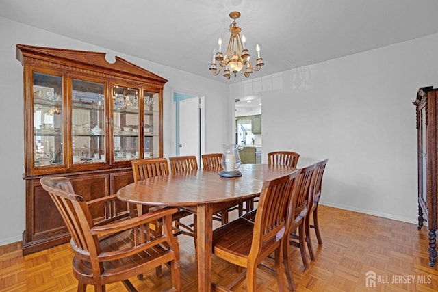 dining space with an inviting chandelier and baseboards