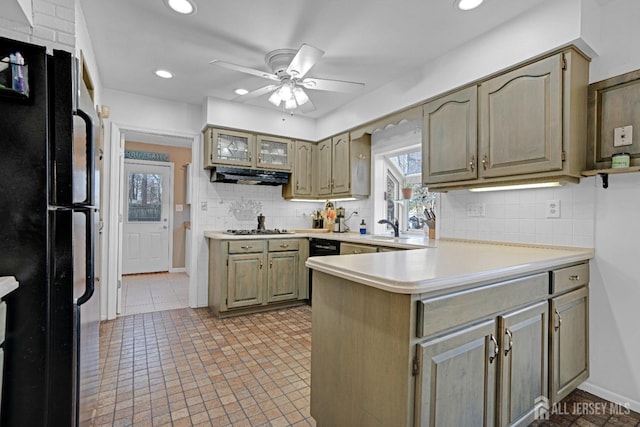 kitchen featuring light countertops, freestanding refrigerator, gas cooktop, a peninsula, and exhaust hood