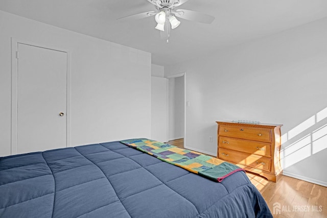 bedroom featuring light wood-style floors, ceiling fan, and baseboards