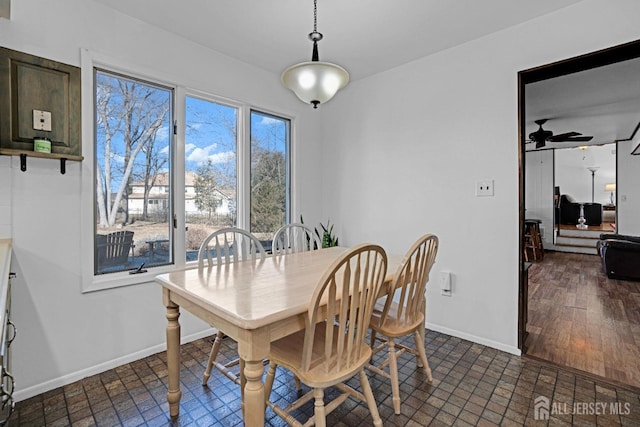 dining area with a ceiling fan and baseboards