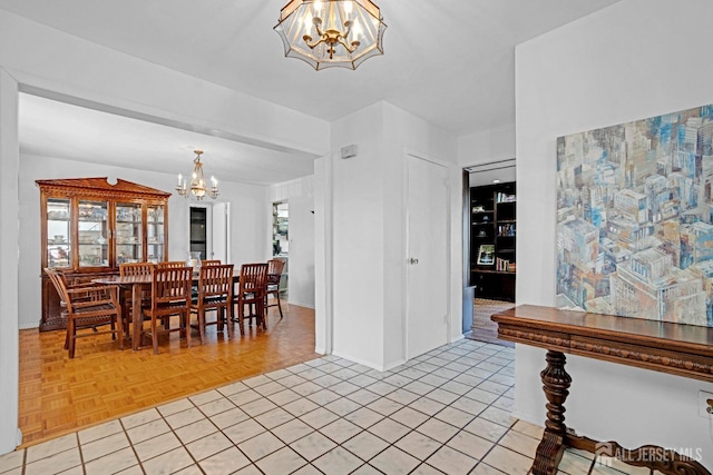 dining space featuring baseboards, light tile patterned flooring, and an inviting chandelier