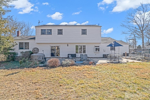 back of property with a yard, a patio, and fence