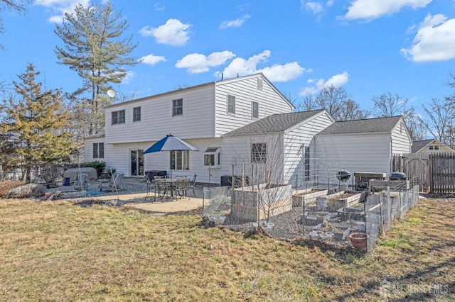 back of house with a yard, a patio, fence, and a garden