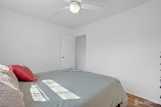 bedroom with ceiling fan, baseboards, and wood finished floors