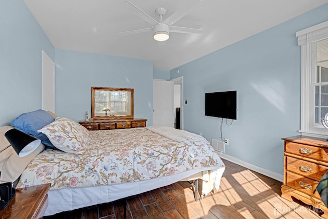 bedroom featuring visible vents, ceiling fan, baseboards, and wood finished floors