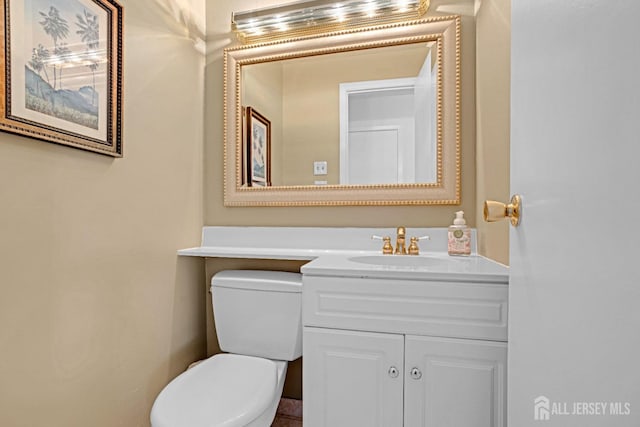 half bathroom with toilet and vanity