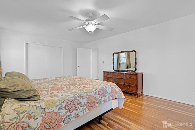 bedroom featuring a closet, ceiling fan, baseboards, and wood finished floors