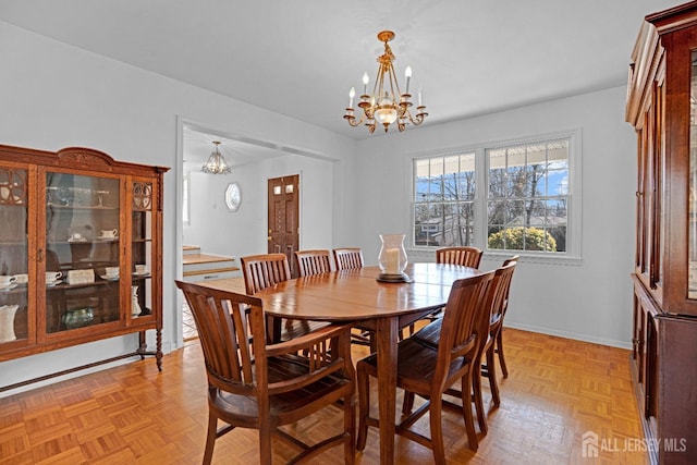 dining area featuring baseboards and an inviting chandelier