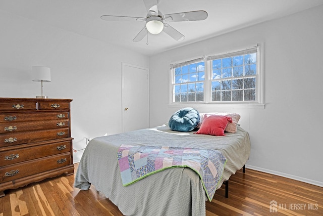 bedroom featuring ceiling fan, baseboards, and wood finished floors