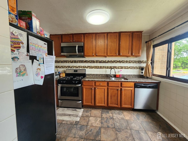 74 Probasco Rd, East Windsor, NJ 08520 - kitchen with stainless steel appliances, brown cabinets, dark stone finish flooring, decorative backsplash, and a textured ceiling