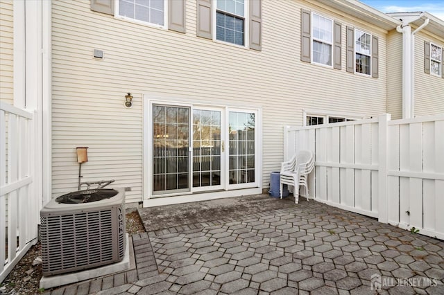 view of patio featuring central AC and fence