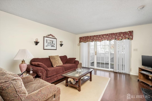 living room with a textured ceiling and wood finished floors