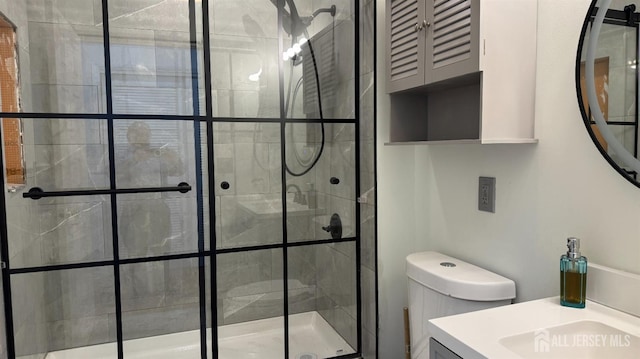 bathroom with vanity, toilet, and a shower stall