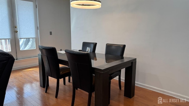 dining space featuring baseboards and wood finished floors