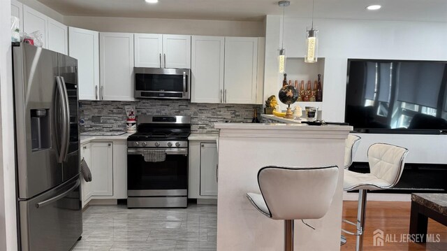 kitchen with light countertops, decorative backsplash, stainless steel appliances, and recessed lighting