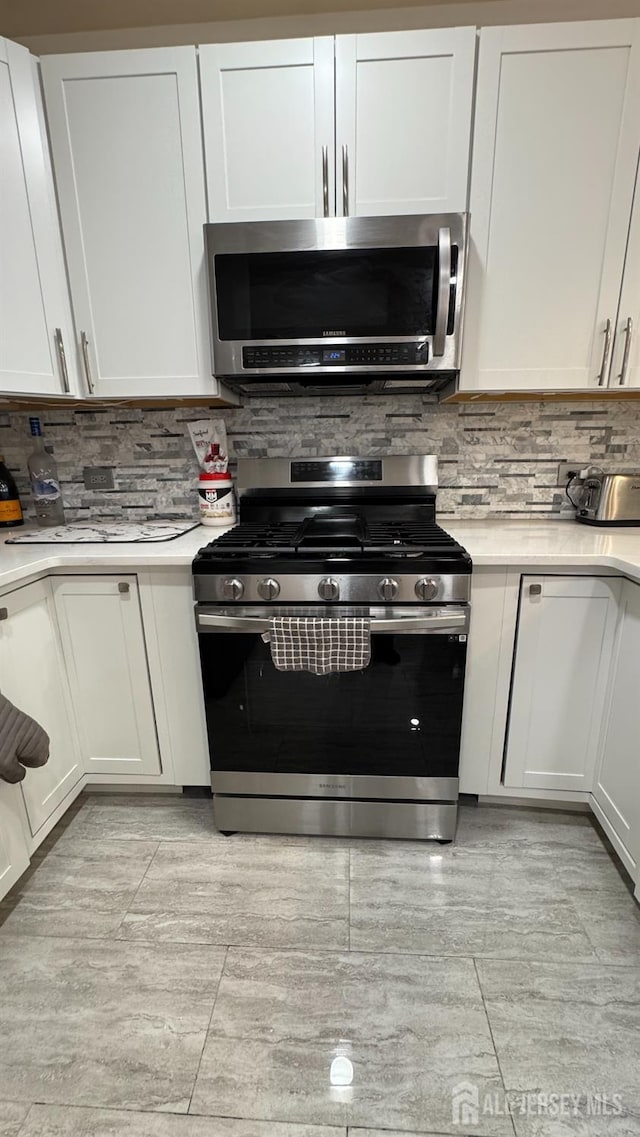 kitchen featuring light countertops, appliances with stainless steel finishes, and tasteful backsplash