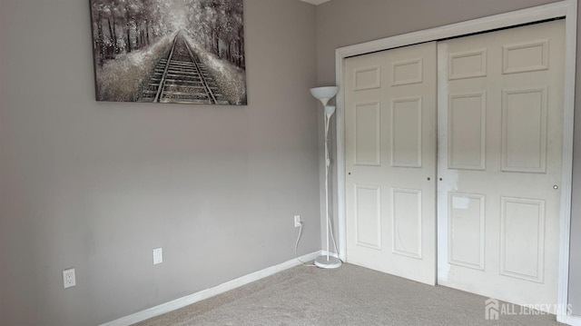 unfurnished bedroom featuring a closet, baseboards, and carpet floors