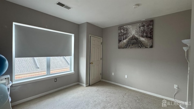 unfurnished bedroom featuring baseboards, visible vents, and carpet