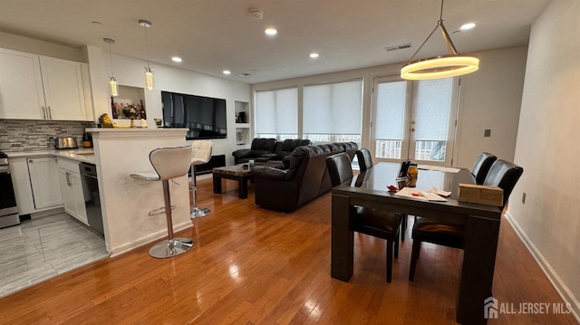 living room with baseboards, recessed lighting, visible vents, and light wood-type flooring