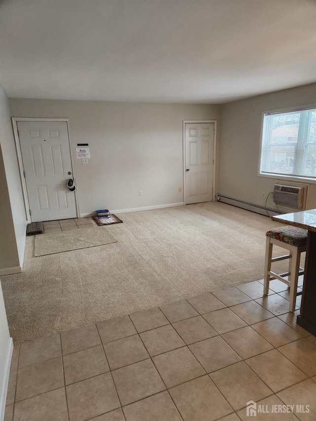 unfurnished living room with light carpet, a wall unit AC, baseboards, and light tile patterned floors