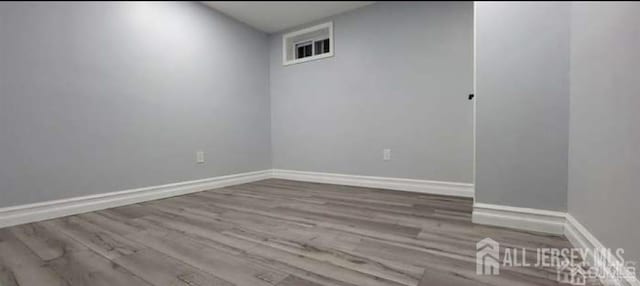 unfurnished room featuring baseboards and wood finished floors